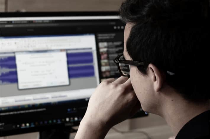 Человек в очках смотрит на экран компьютера с всплывающим окном