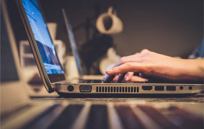 Hands typing on laptop keyboard